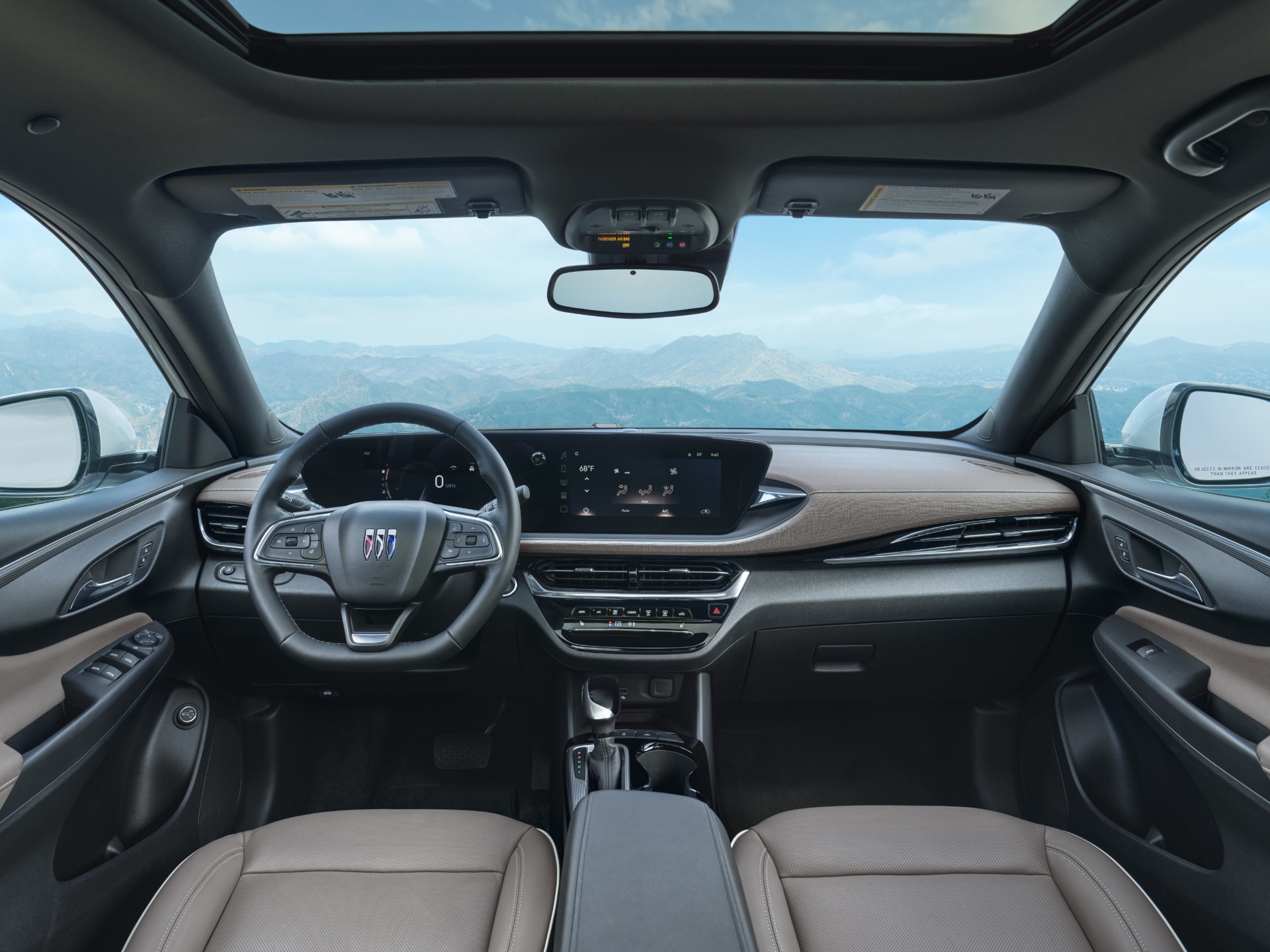 The Brown and Black Dashboard Interior of a Buick Envision, With a Panoramic View of Mountains Outside