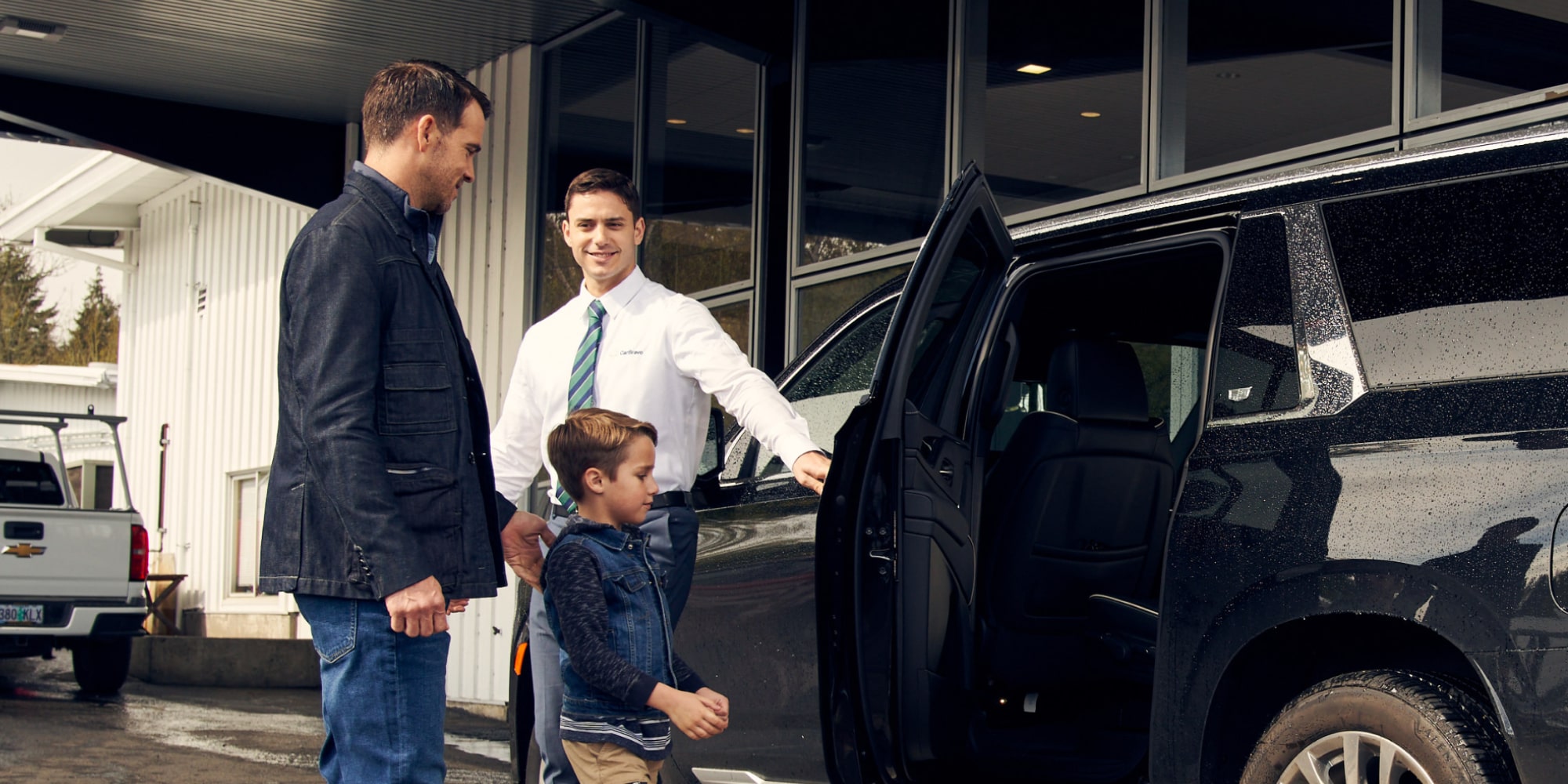 A CarBravo Associate Opening a Vehicle Door for a Man and his Son