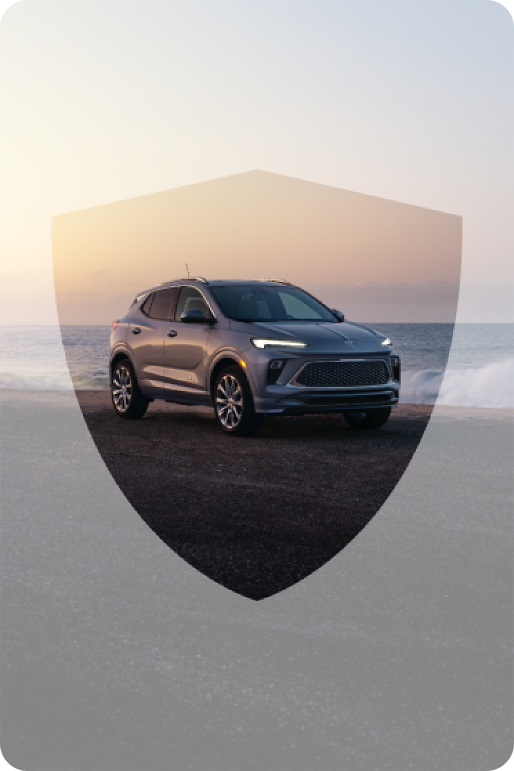A Buick Vehicle in Front of the Ocean with the Sunset in the Background, with the Protection Plans Shield Shape Around the Vehicle.