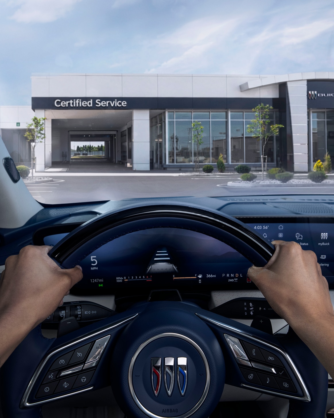 A Woman in the Driver Seat of a Vehicle, Looking at the Certified Technician Behind the Desk at a Buick Certified Service Dealership.
