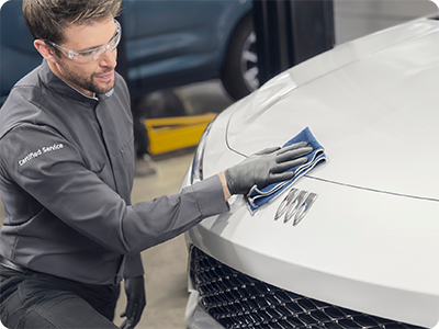 A Certified Service Technician Wiping Down a White Buick Vehicle