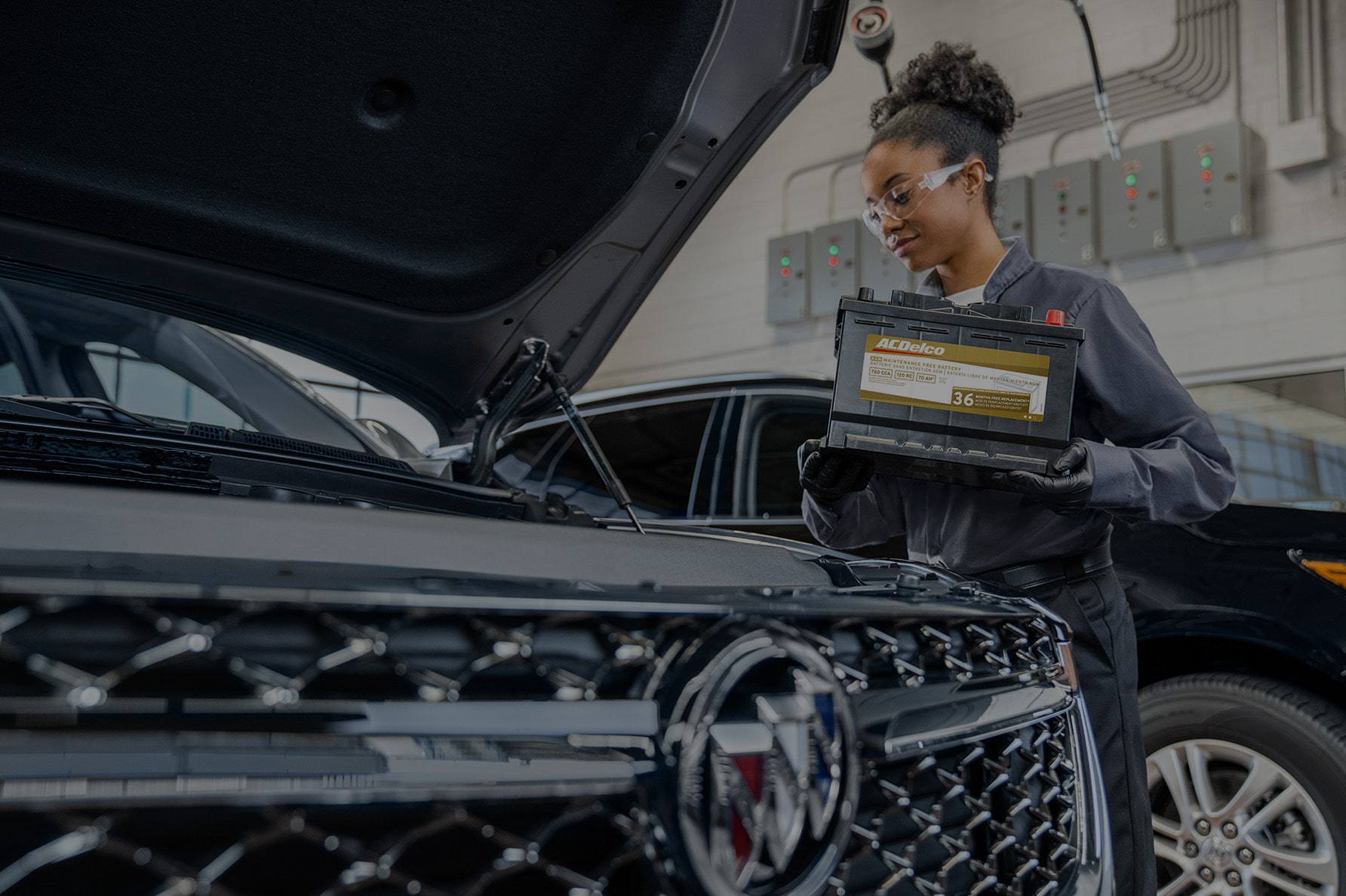 A Service Technician Holding a Battery Next to a Vehicle
