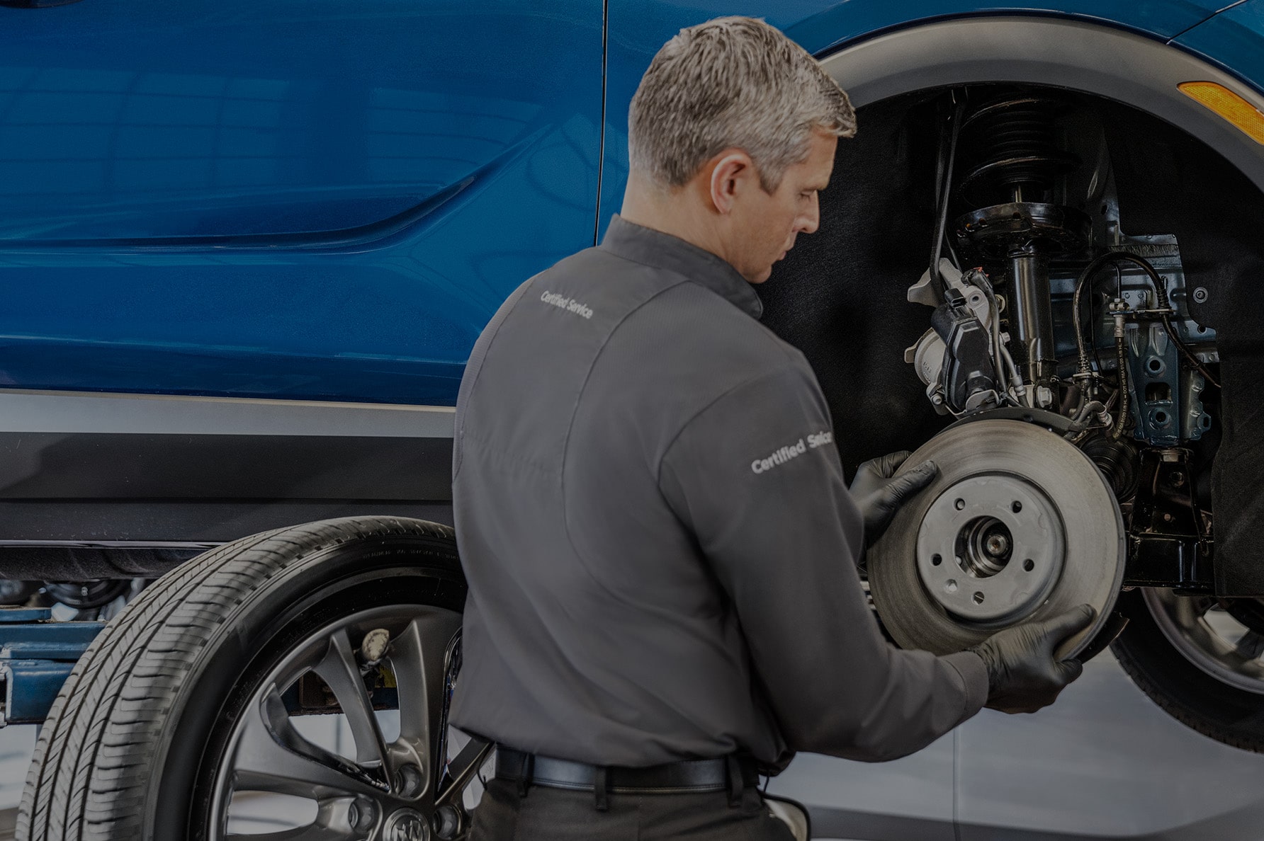 A Service Technician Working on the Brakes of a Lifted Vehicle