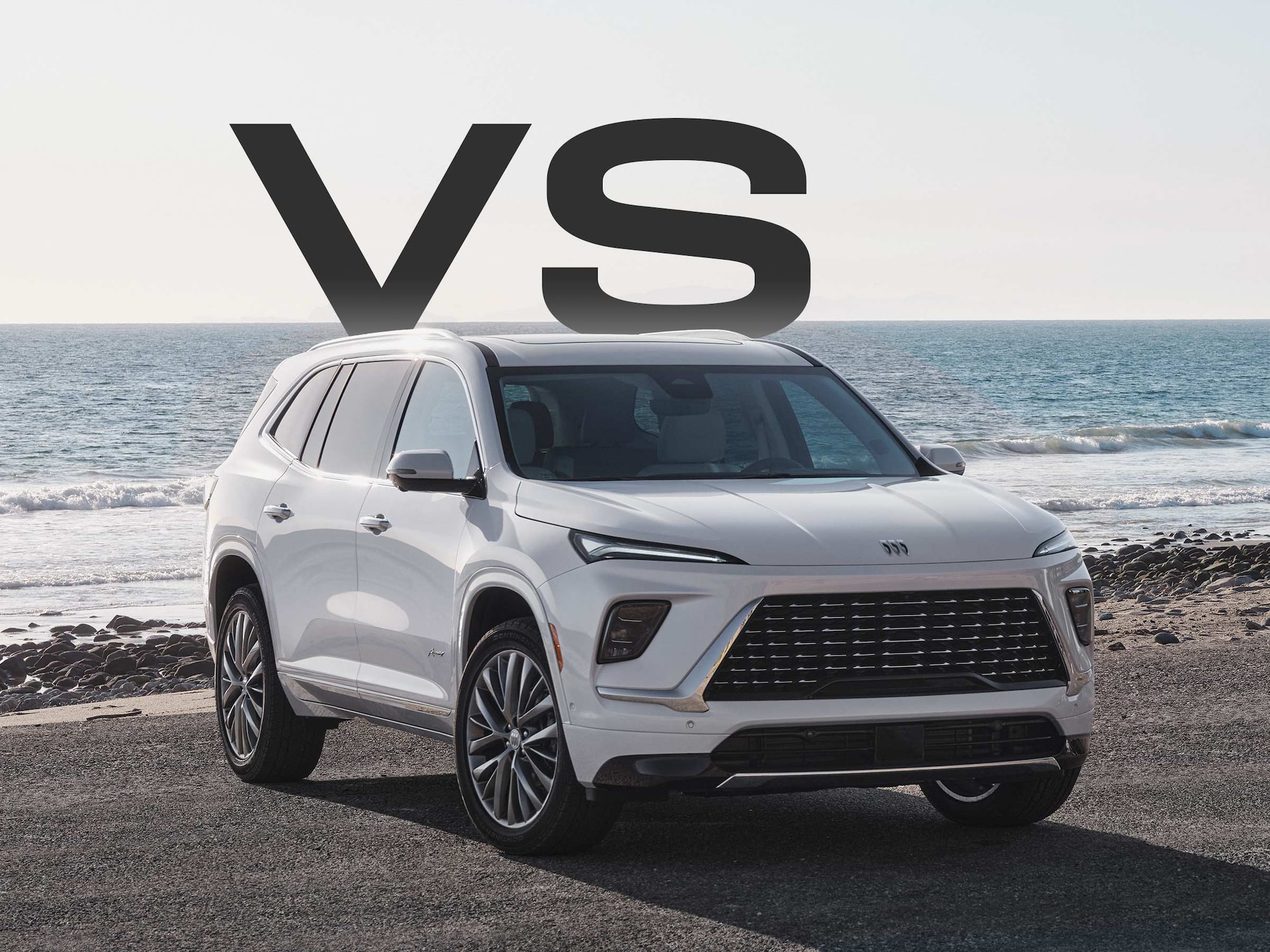 Front Three-quarters View of a White Buick Enclave Parked on a Beach as Waves Crash on the Shoreline
