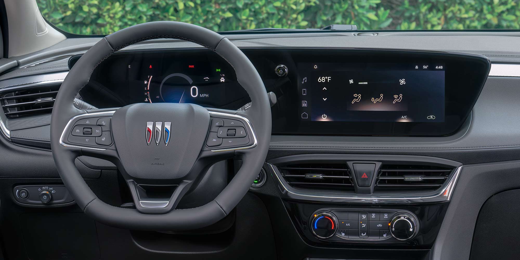 The Interior Dashboard of the Buick Envision Shows a Digital Screen and Steering Wheel with the Buick Logo