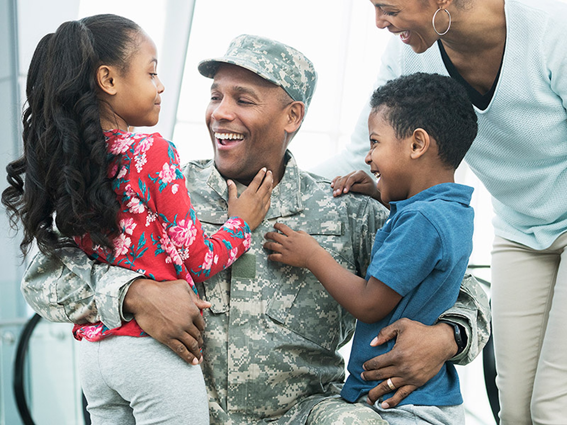 Military Dad with family holding his children