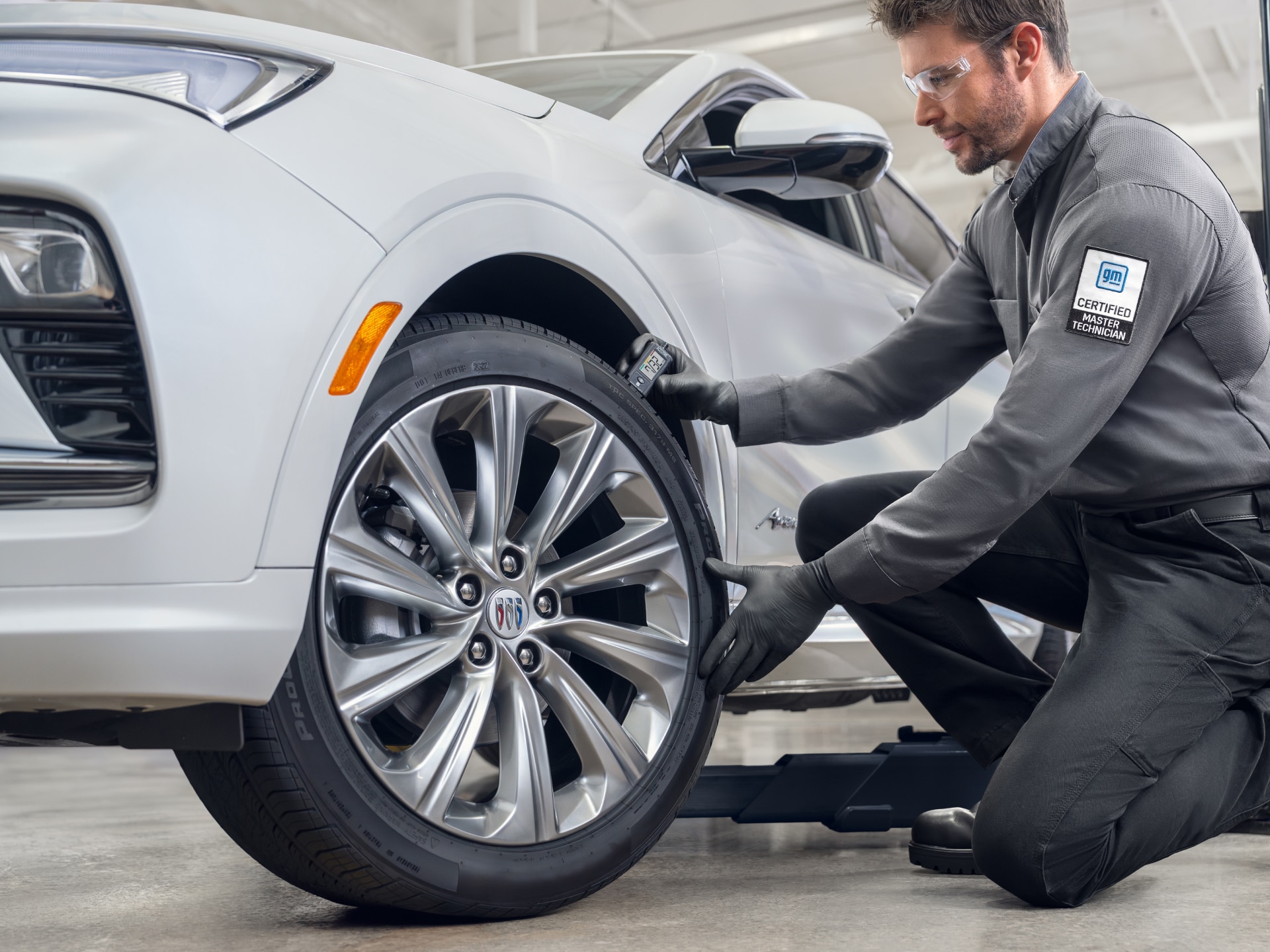 Master Technician measuring Tire Pressure on Buick vehicle