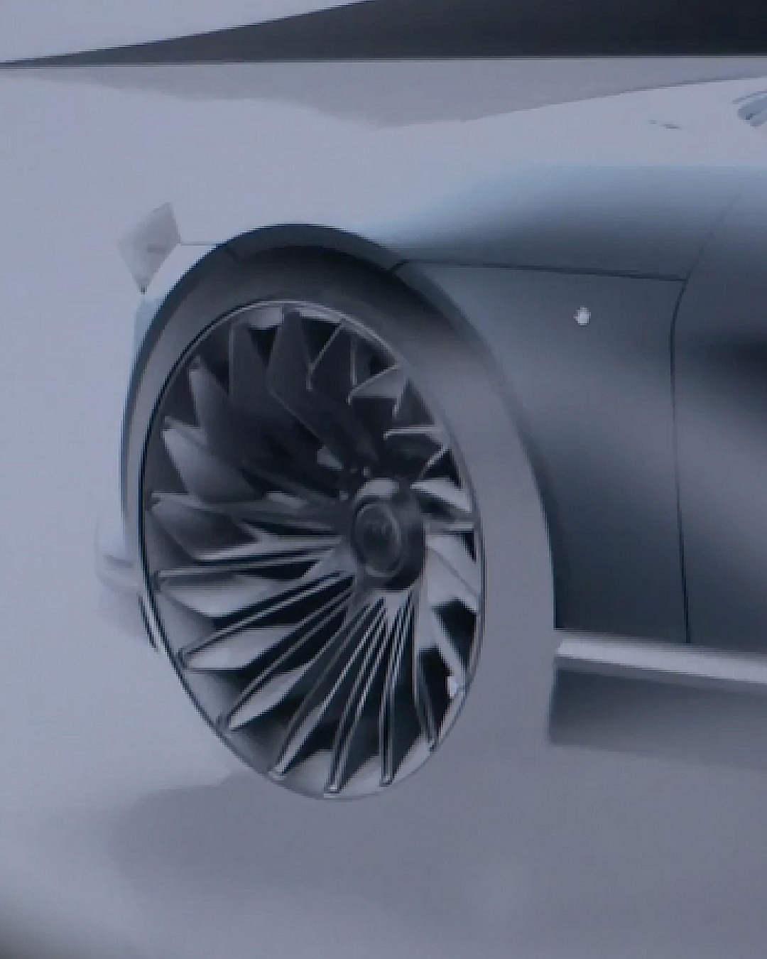A Person Looks at a Digital Projection of a Sleek Gray Car With a Distinctive Wheel Design