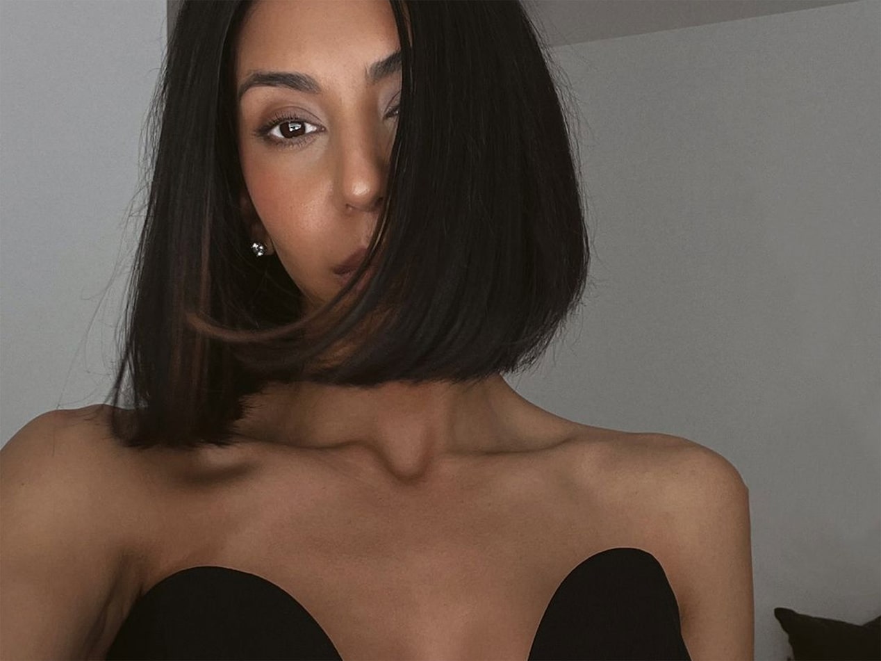 Kayla Seah With Short Dark Hair Wearing a Strapless Black Top Looking At The Camera