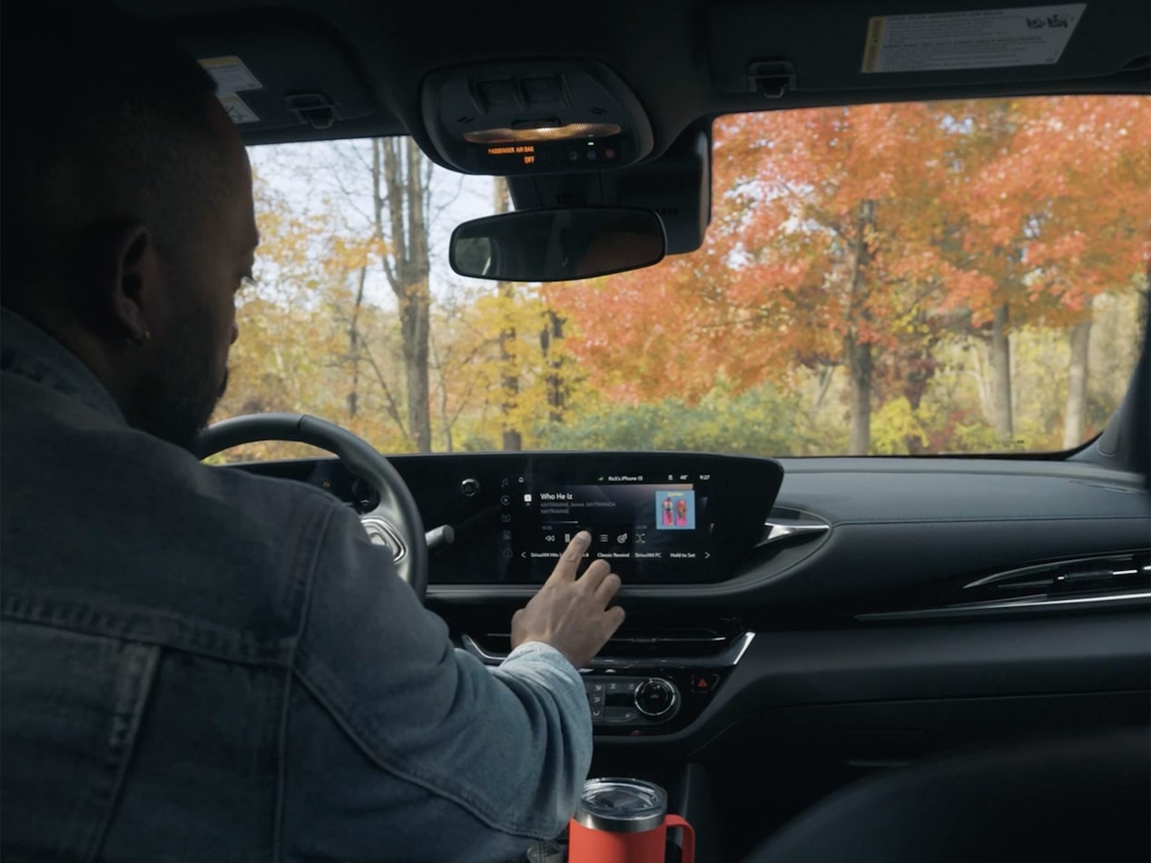 Rick Southers Operating the Infotainment System in a Buick Envista with Autumn Trees in the Background