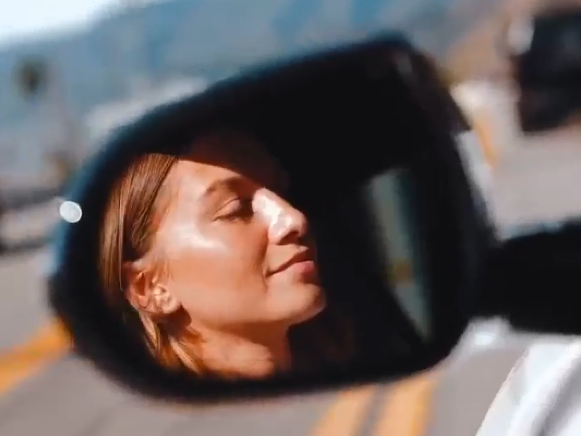 Anna Sitar's Face Reflected in a Buick's Side Mirror with Sunlight Highlighting Her Features