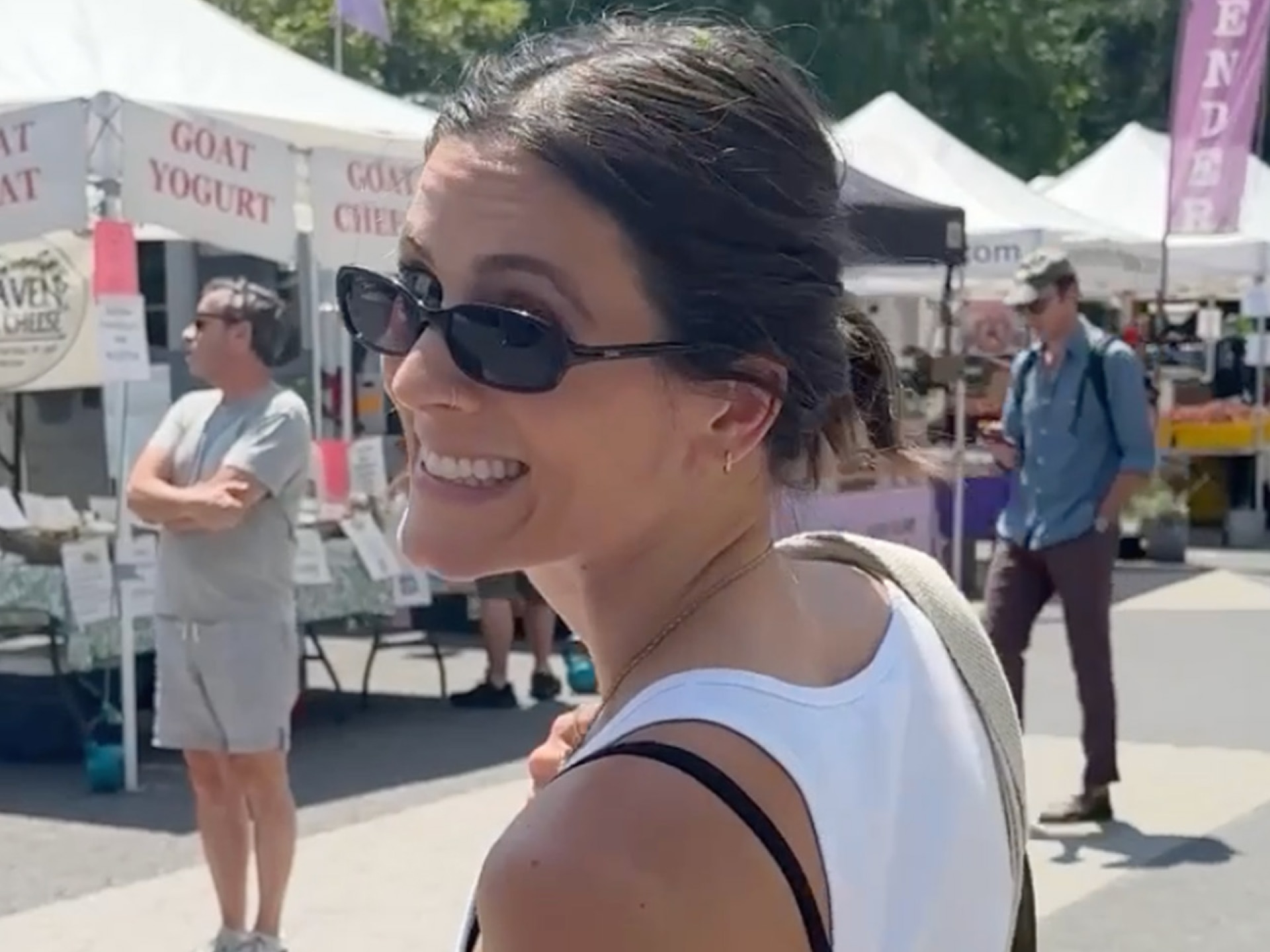 Influencer Eden Grinshpan Smiling and Looking Over Her Shoulder at an Outdoor Market