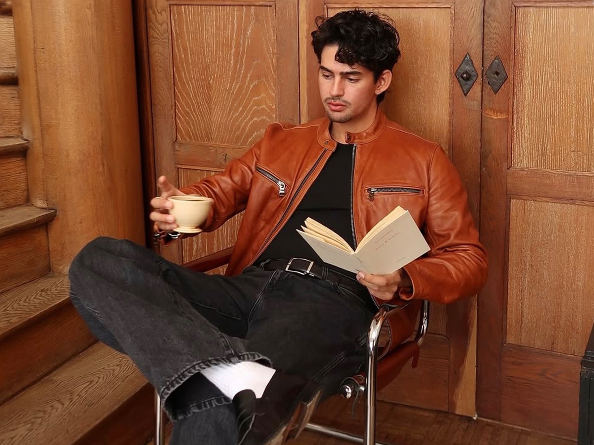 Head-shot Picture of the Influencer Marco Zamora Sitting in a Chair Reading a Book