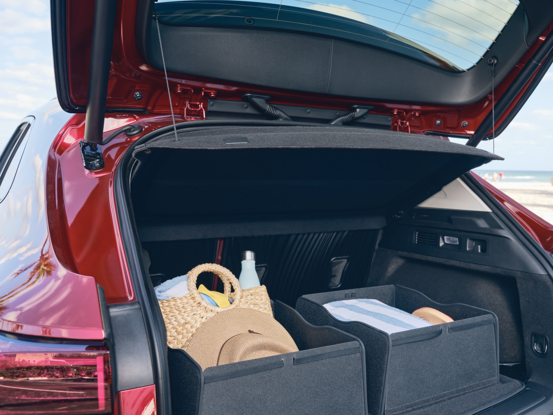 The Buick Envisions Opened Liftgate with the Premium Carpeted Cargo Area Mat with Integrated Cargo Bins Holding Beach Supplies