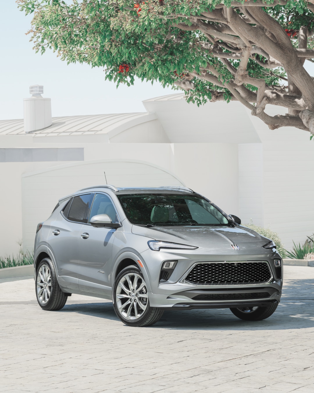 A Gray Buick SUV Parked in front of a Modern White Building with Green Landscaping