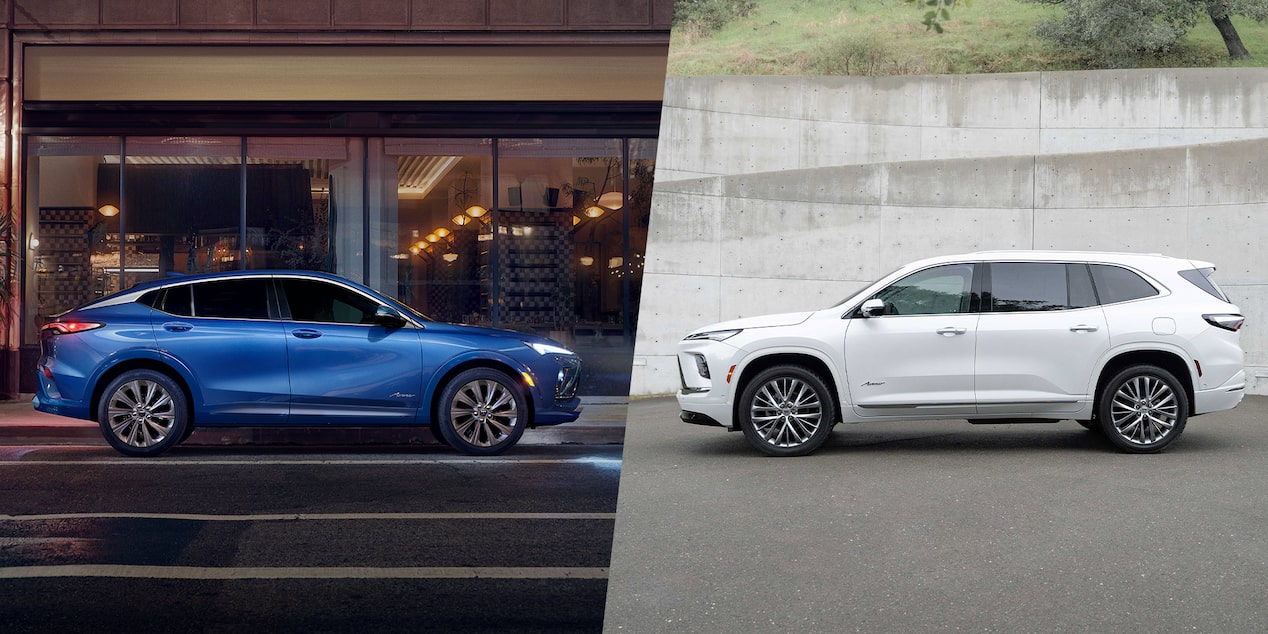 A Blue Buick SUV Parked by a City Street at Night Alongside a White Buick SUV Next to a Concrete Wall