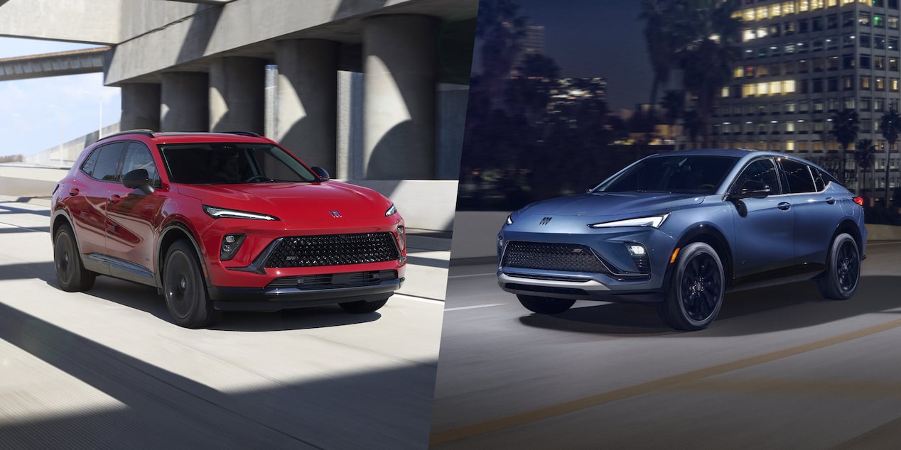 A Red Buick Envision and a Blue Buick Envista Driving Outdoors in Front of Modern Buildings