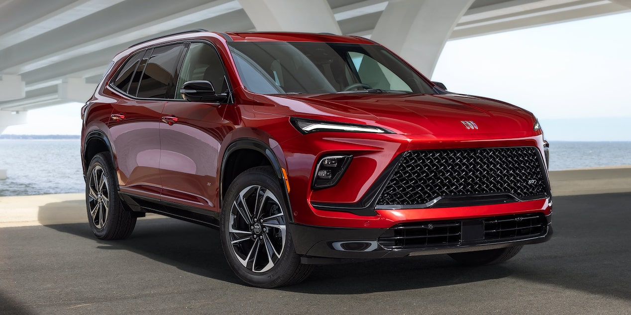 A Vibrant Red Buick Enclave SUV Parked Under a Concrete Bridge Next to the Water