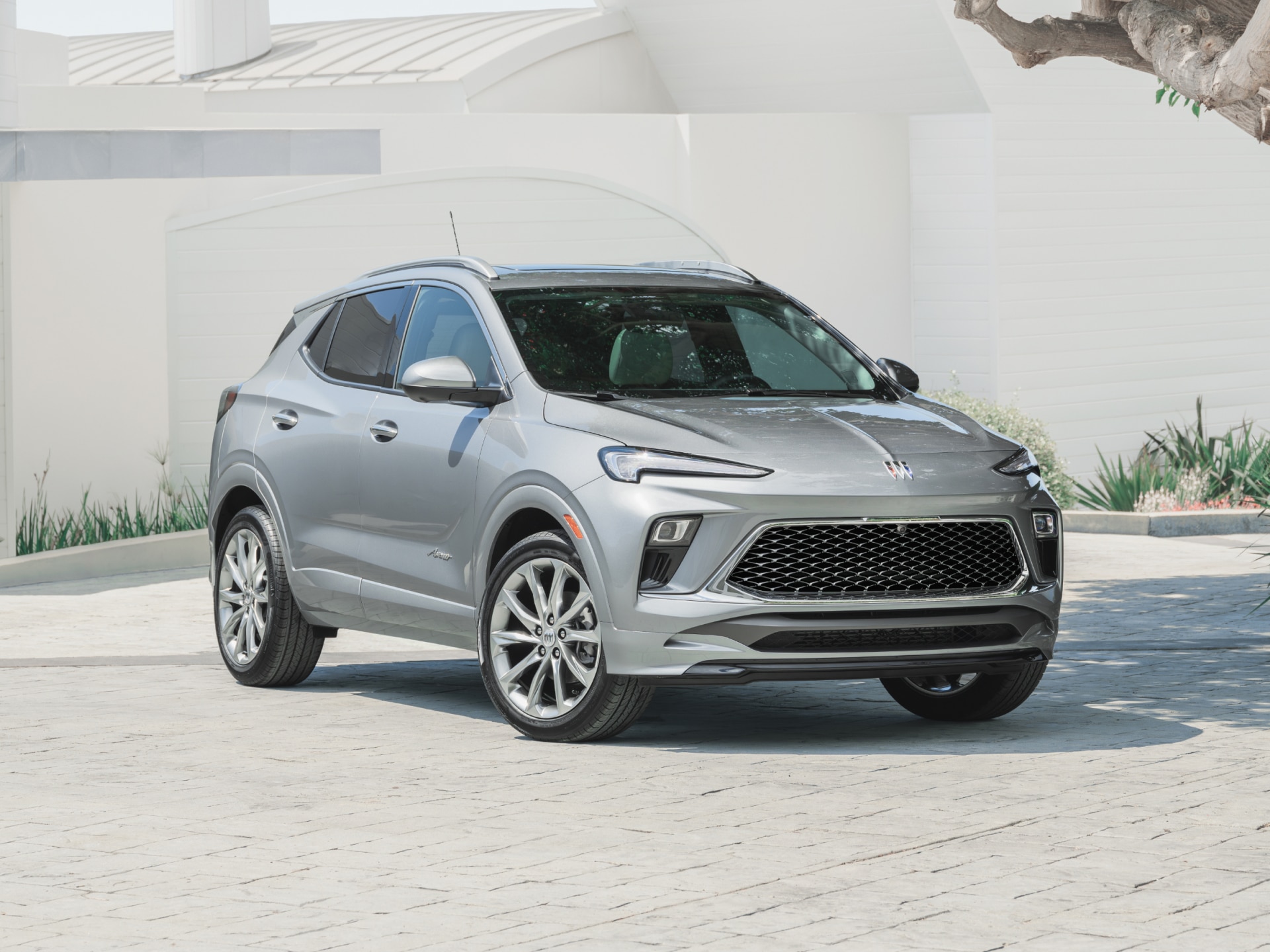 A Gray Buick SUV Parked in front of a Modern White Building with Green Landscaping