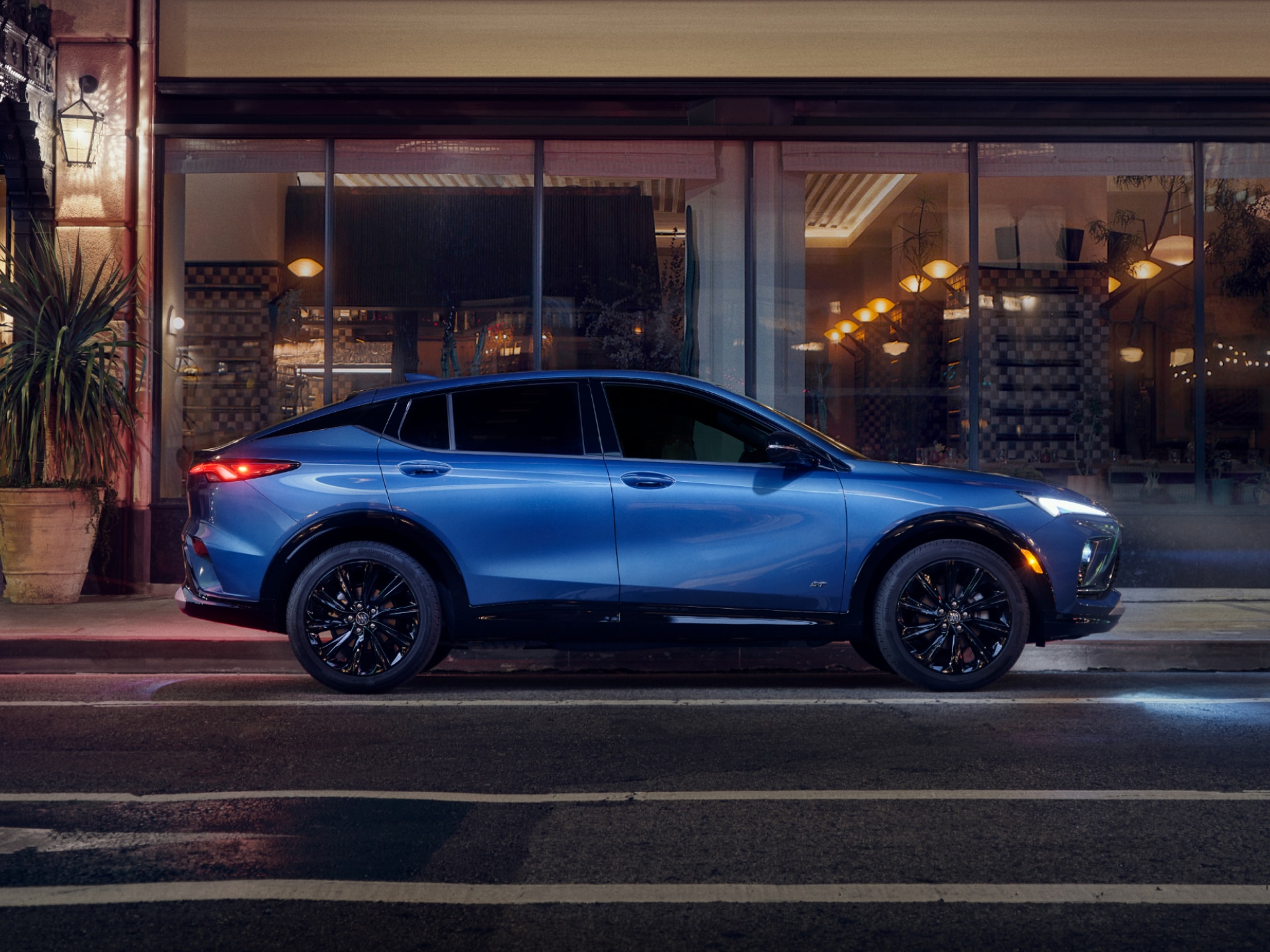 Profile View of the Buick Envista Compact SUV Parked on a City Street at Night
