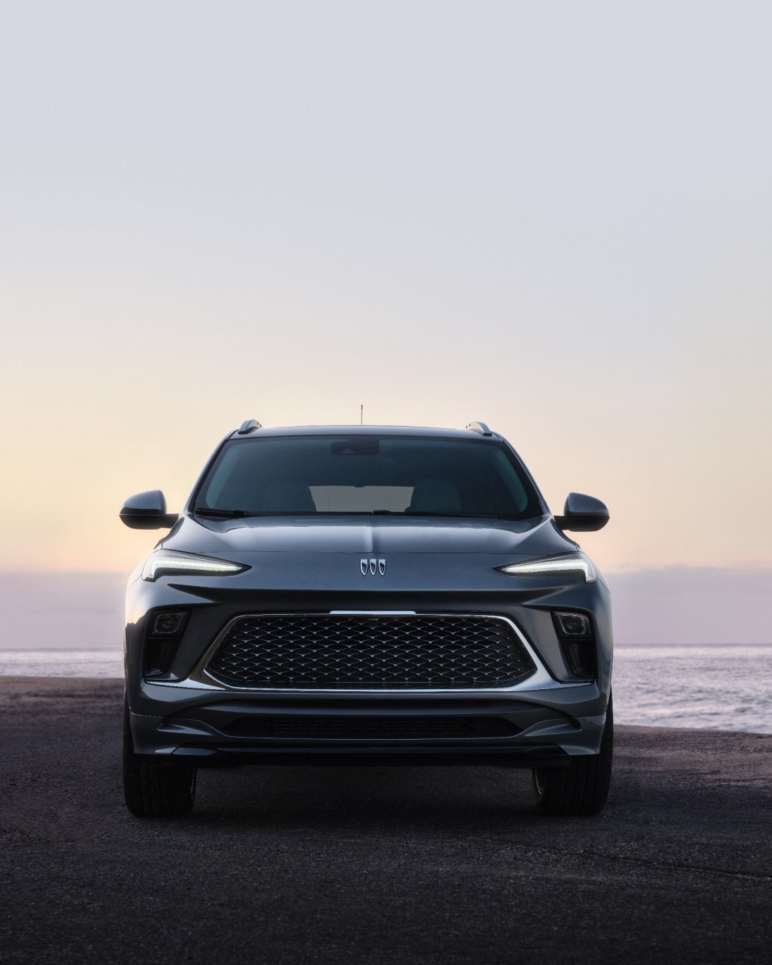 Front View of the Buick Encore GX Parked on a Beach at Sunset