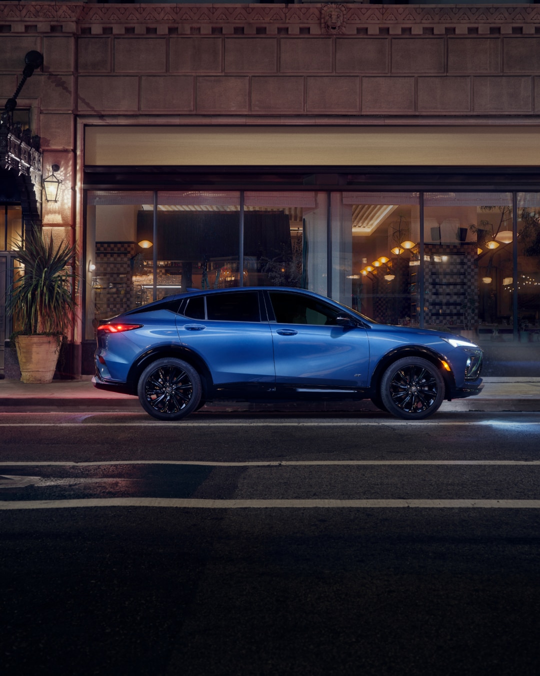 Profile View of the Buick Envista Compact SUV Parked on a City Street at Night