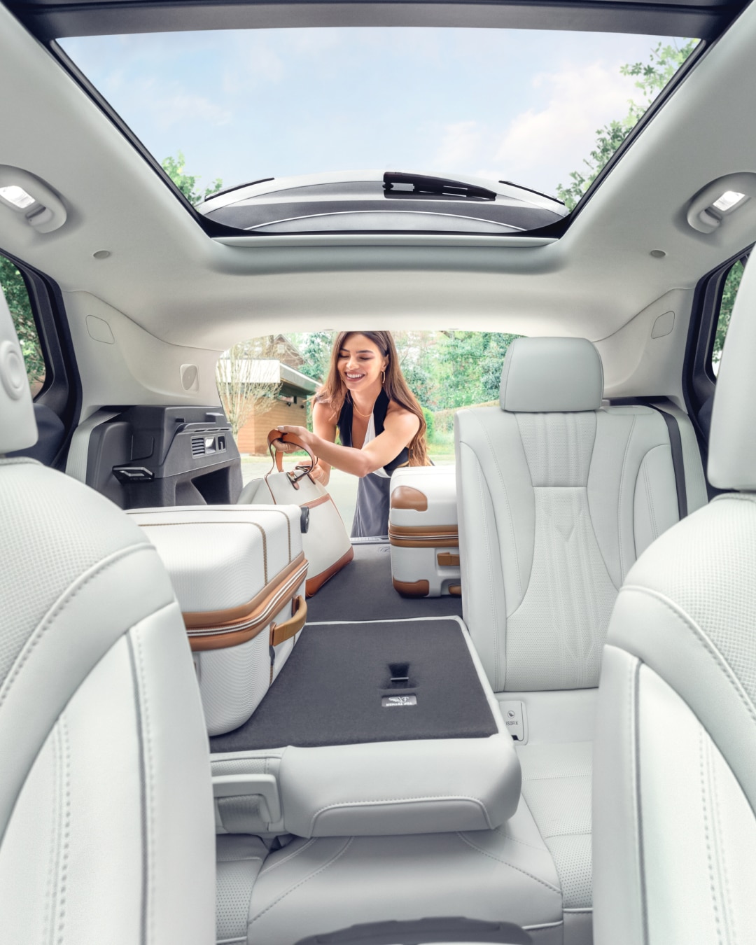 Interior View of a 2025 Buick Envision 5 Passenger SUV with a Person Loading Luggage Into the Trunk