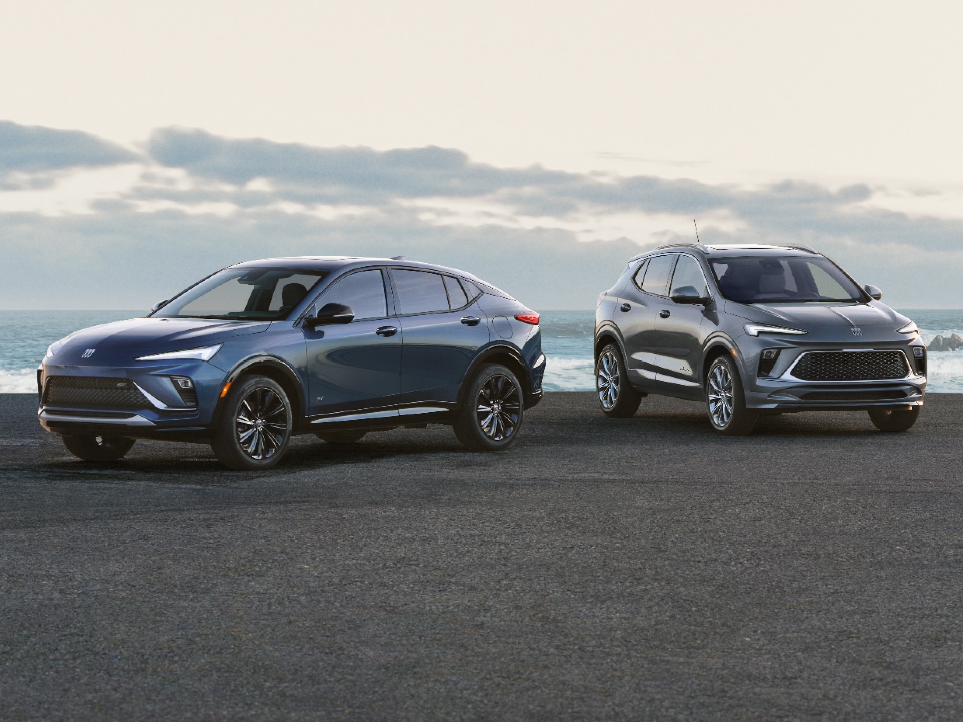 2 Buick Vehicles on an Oceanfront Road Including a Blue Envista and a Gray Encore