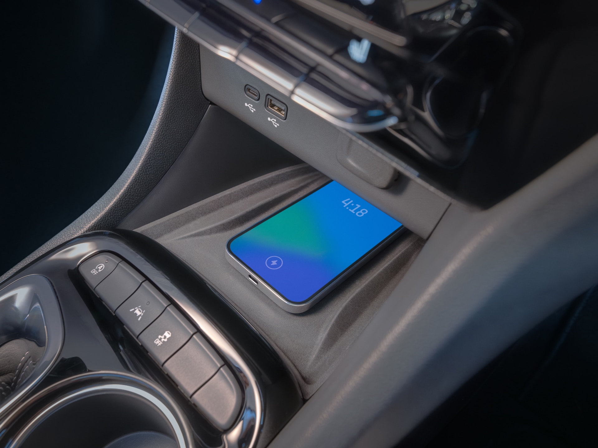 A Smartphone Wirelessly Charges in the Center Console of a Buick SUV, Showing the Time 4:18
