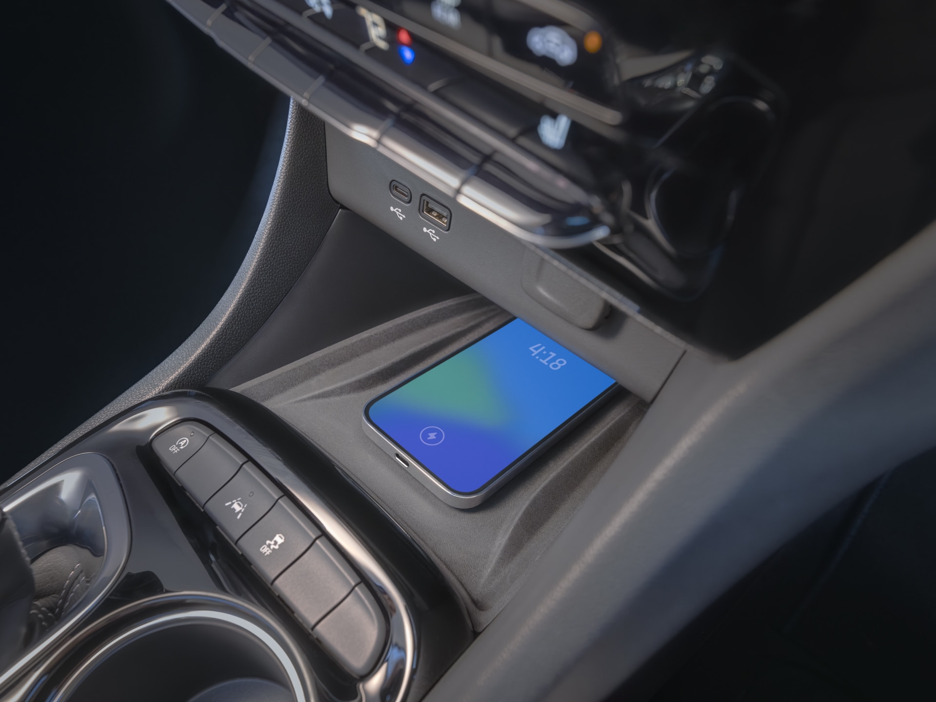 A Phone on the Wireless Charging Compartment Next to the Gear Shift Stick Inside a Buick SUV