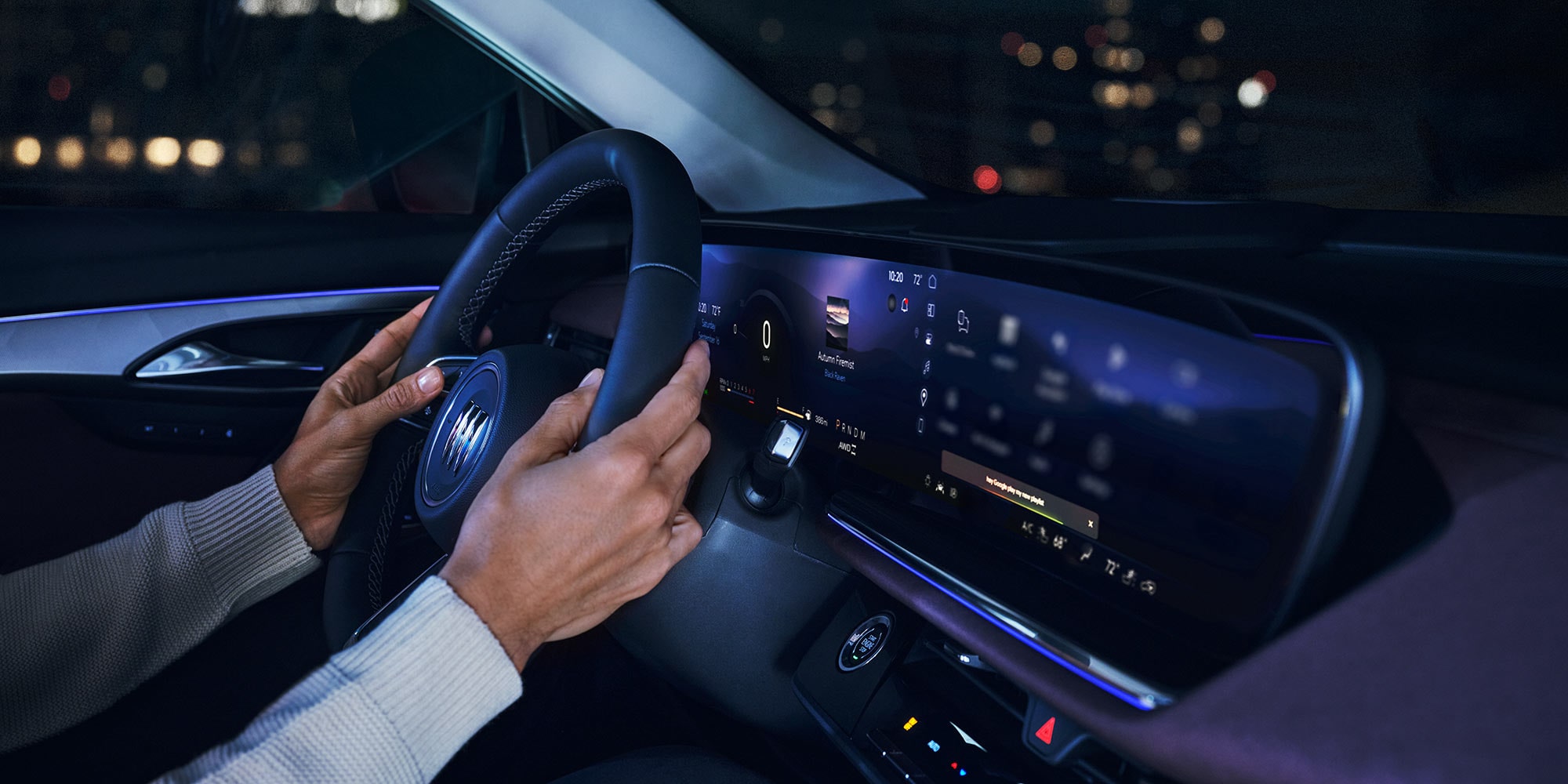 Hands on the Steering Wheel of a Buick Vehicle at Night, Showing the Digital Dashboard Display with Various Icons