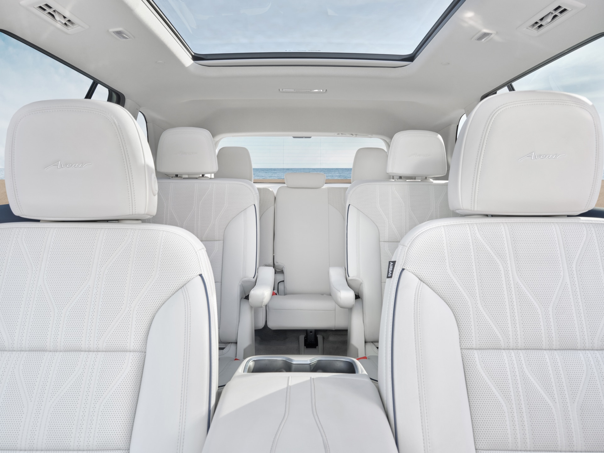 Interior of a Buick Enclave, Showing Rows of White Leather Seats and a Panoramic Sunroof