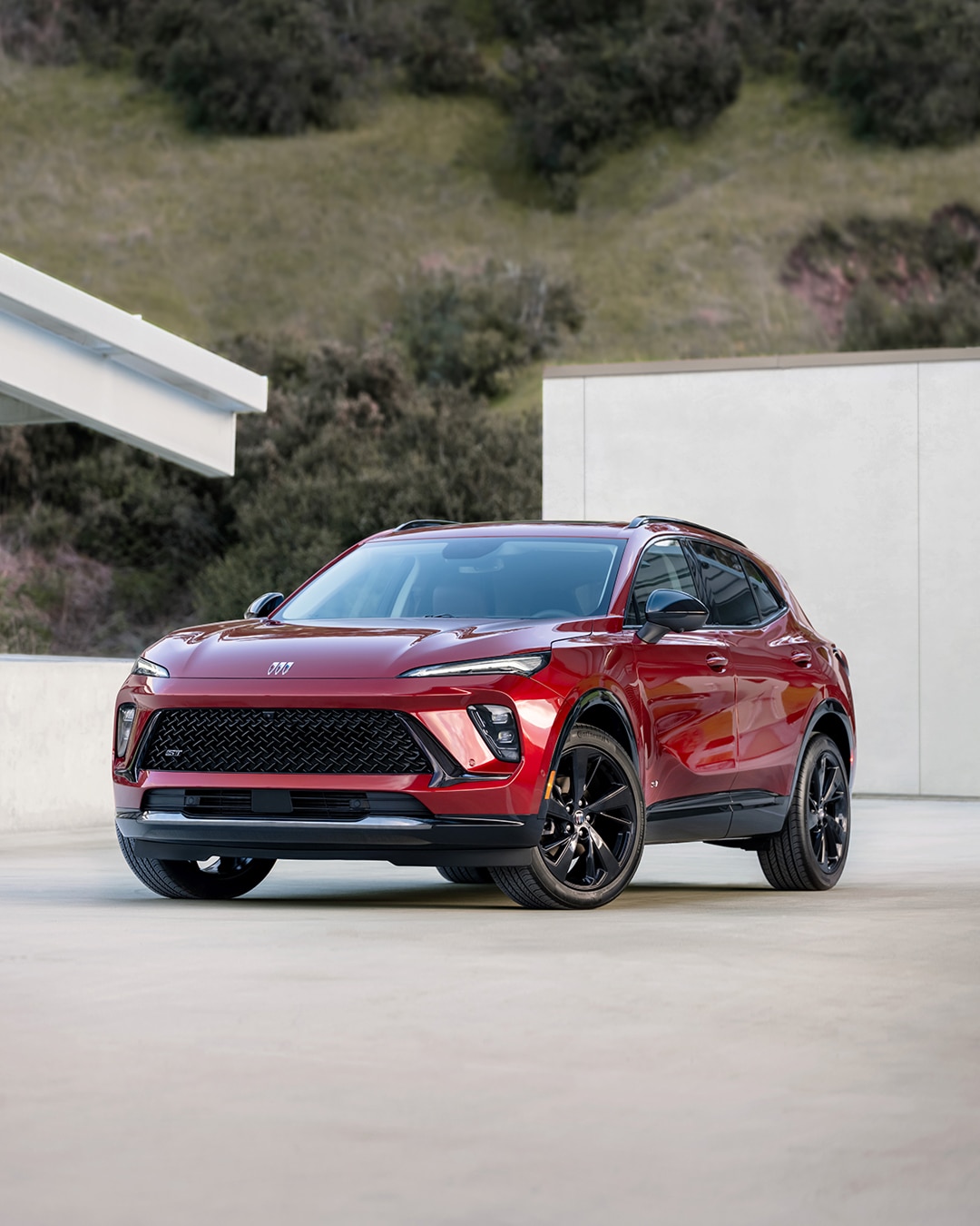 A Front Three-Quarters View of a Red Sport Touring Buick SUV Parked on a Driveway