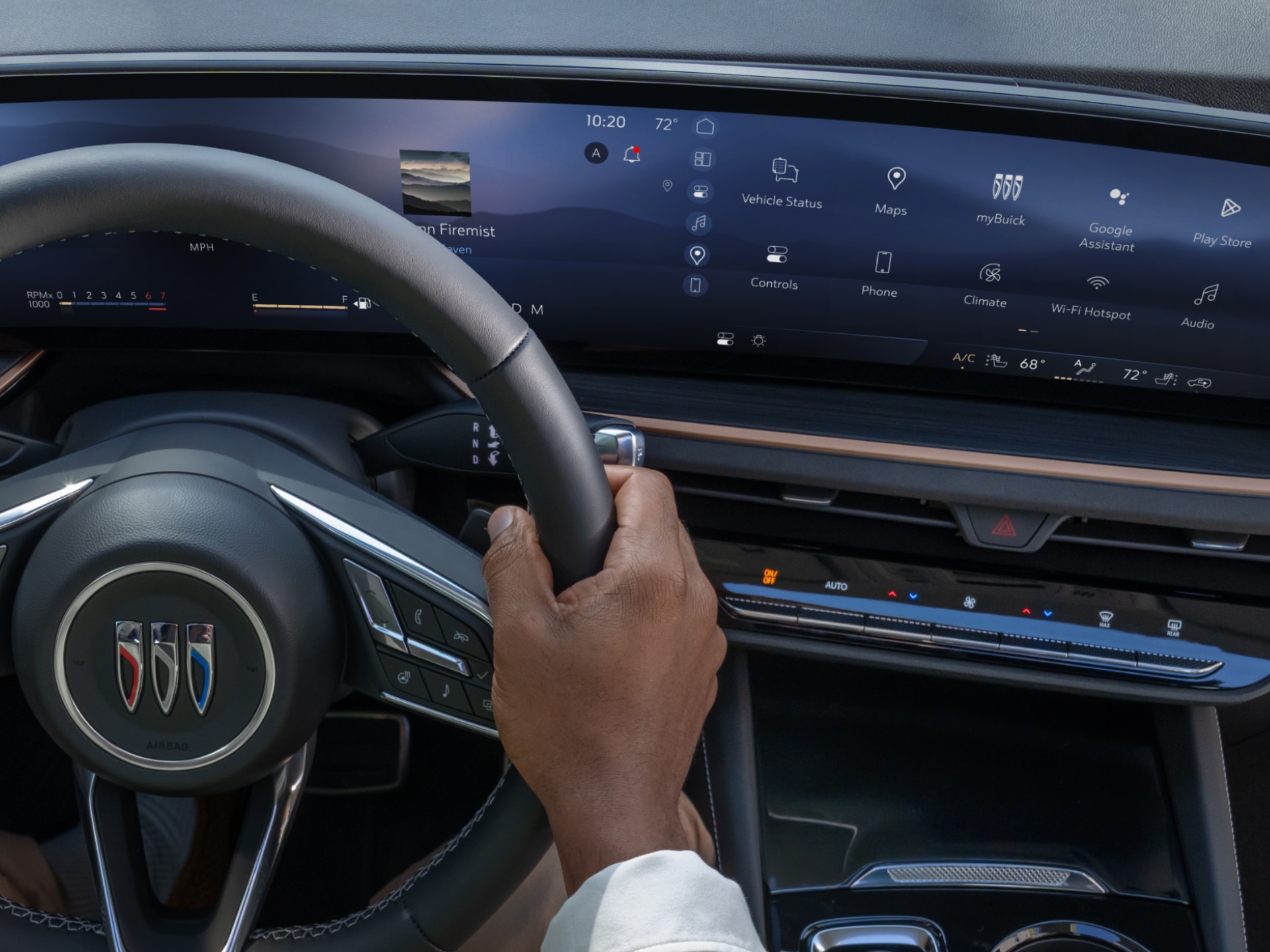 A Driver's Hand Grips the Buick Steering Wheel with a Large Digital Infotainment Screen Displaying Apps