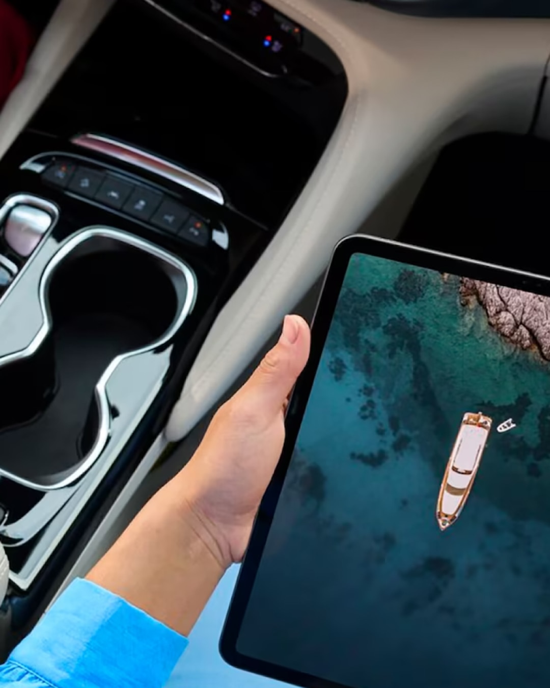 Birds-eye View of Two People Sitting in a Vehicle With One Driving and the Other Using a Tablet