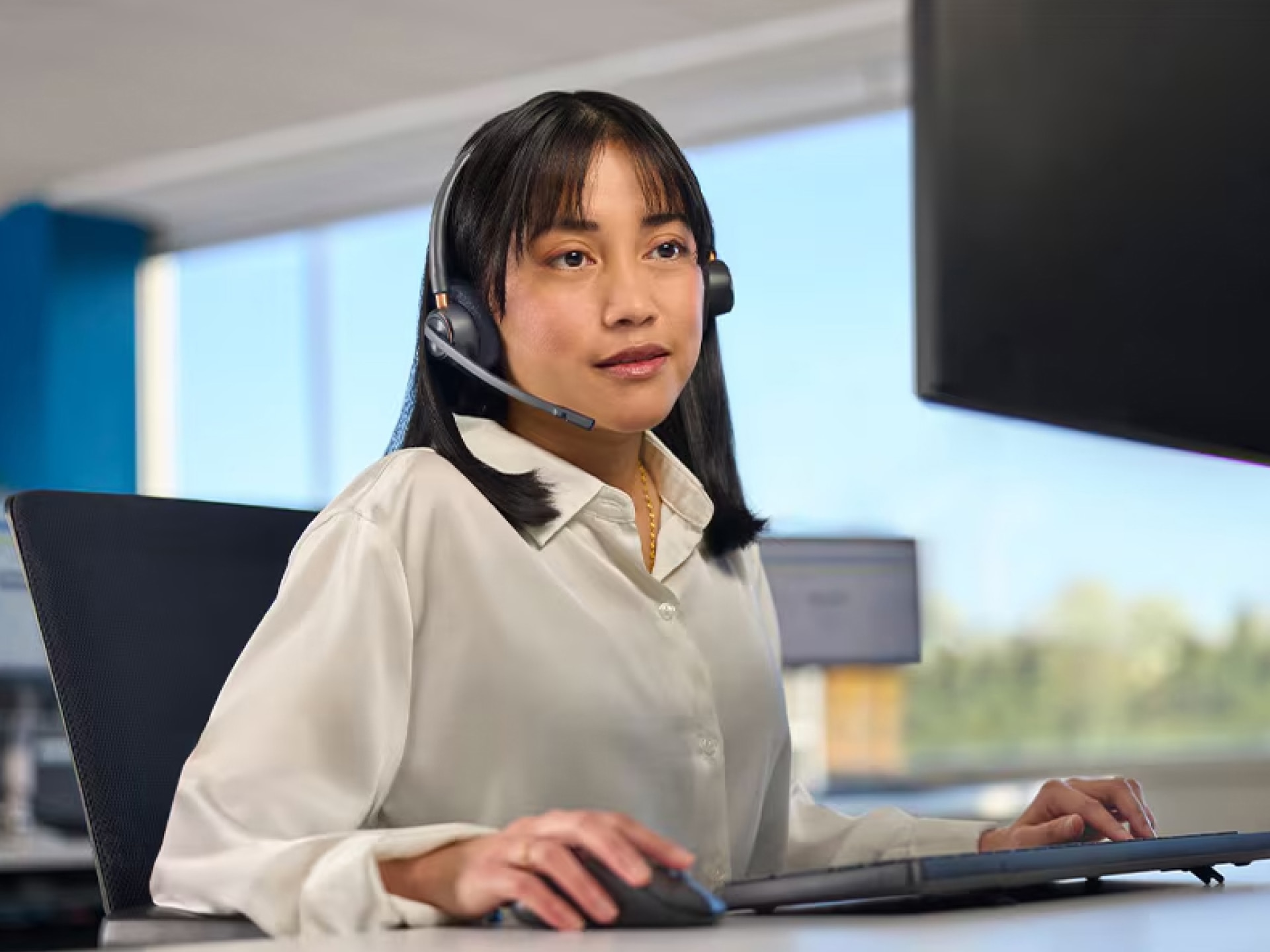 An OnStar Advisor with a Headset on Sitting at a Computer and Ready to Assist OnStar Customers