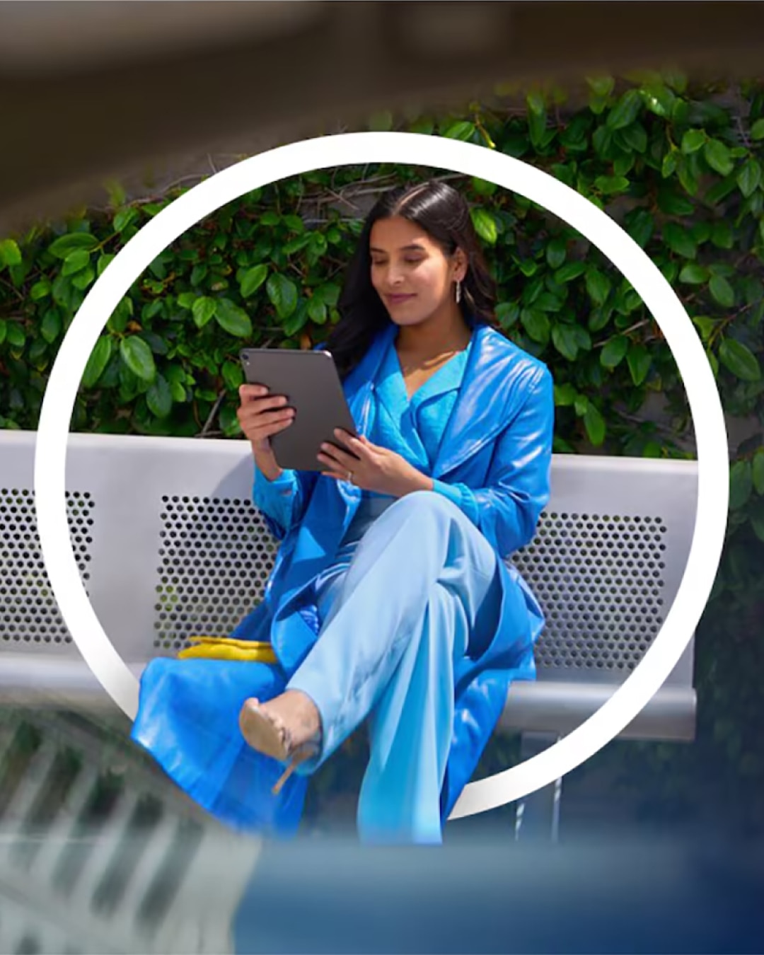 A Woman Sitting on a Park Bench Using her iPad