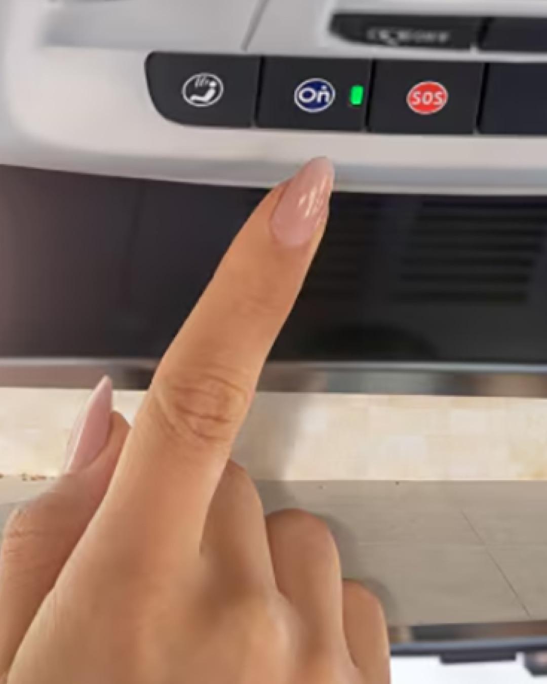 Close-up of a Woman Pressing the OnStar Button in her Vehicle