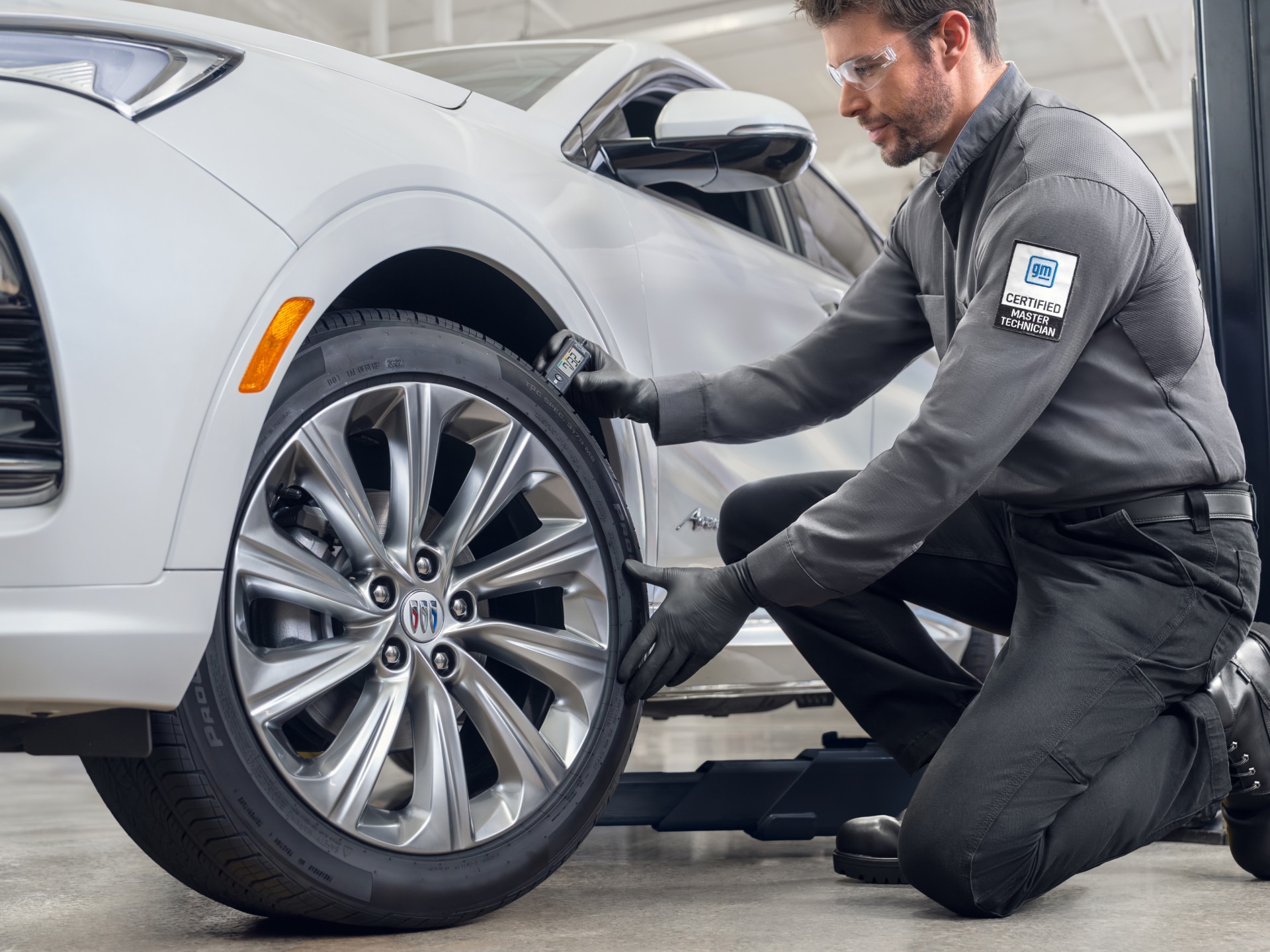 A GM Mechanic Working on a Buick SUVs Tire