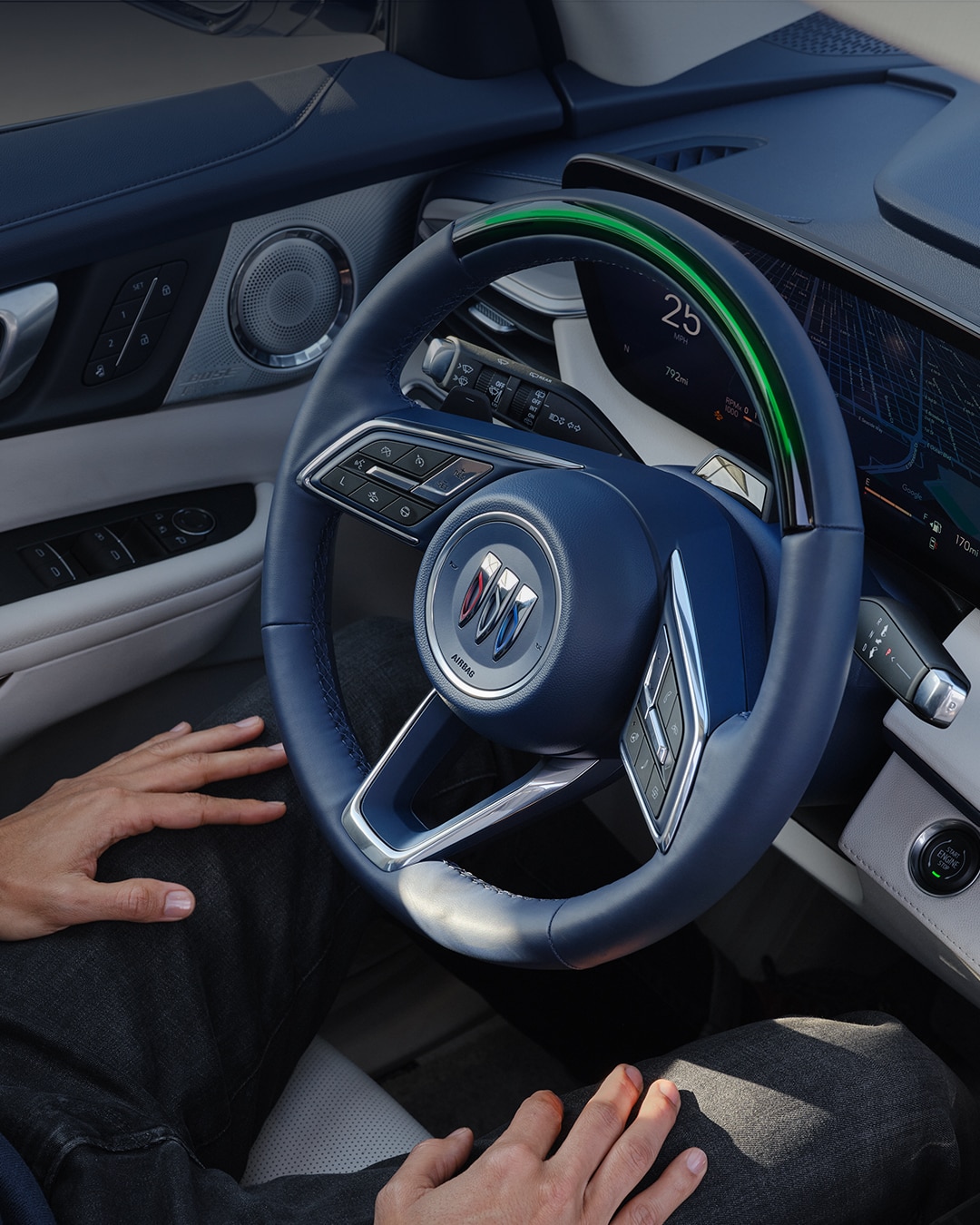 Driver's Hand Resting on their Lap with a Blue Steering Wheel and Buick Logo