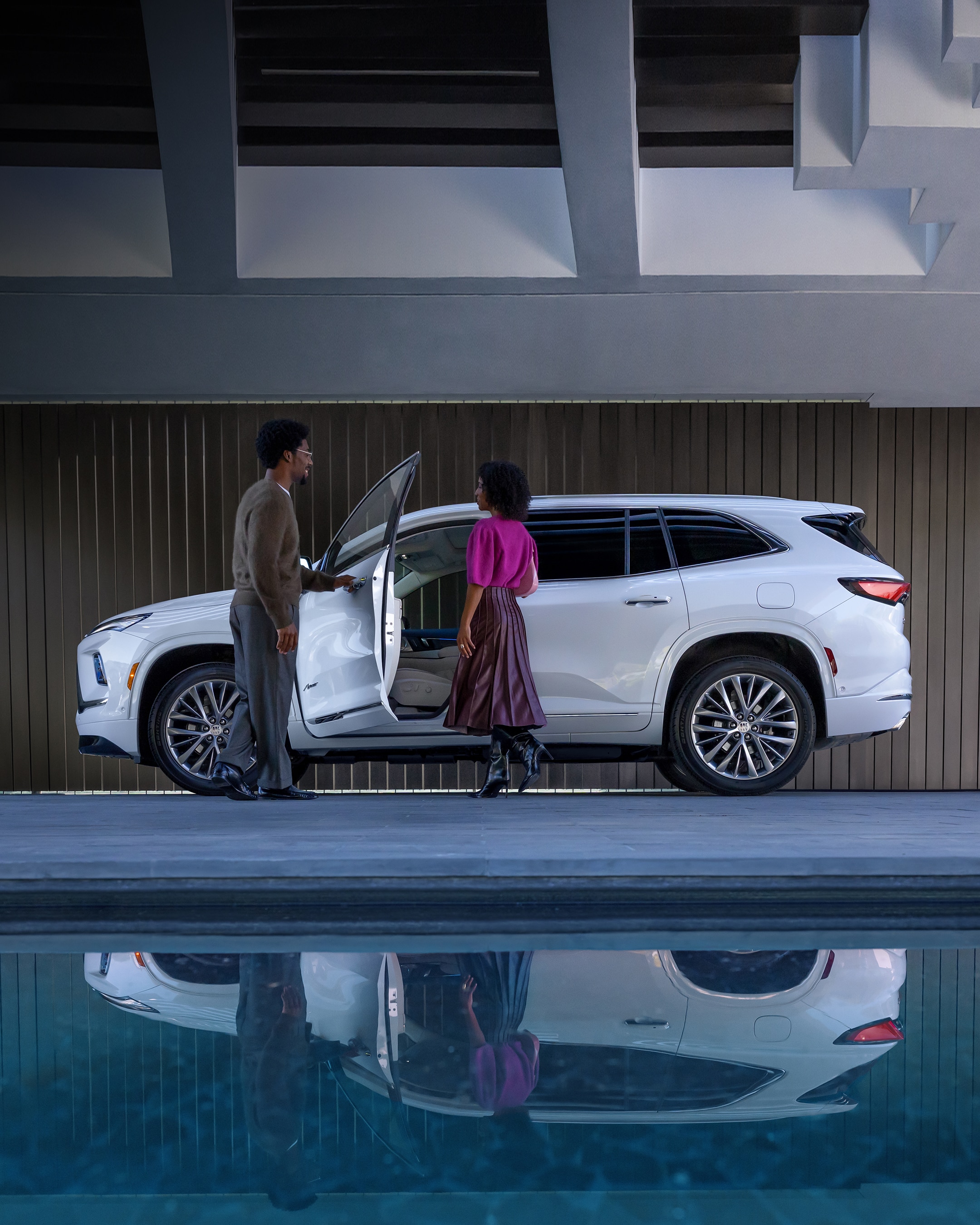 A Couple Standing by a White Buick SUV with the Driver's Side Door Open
