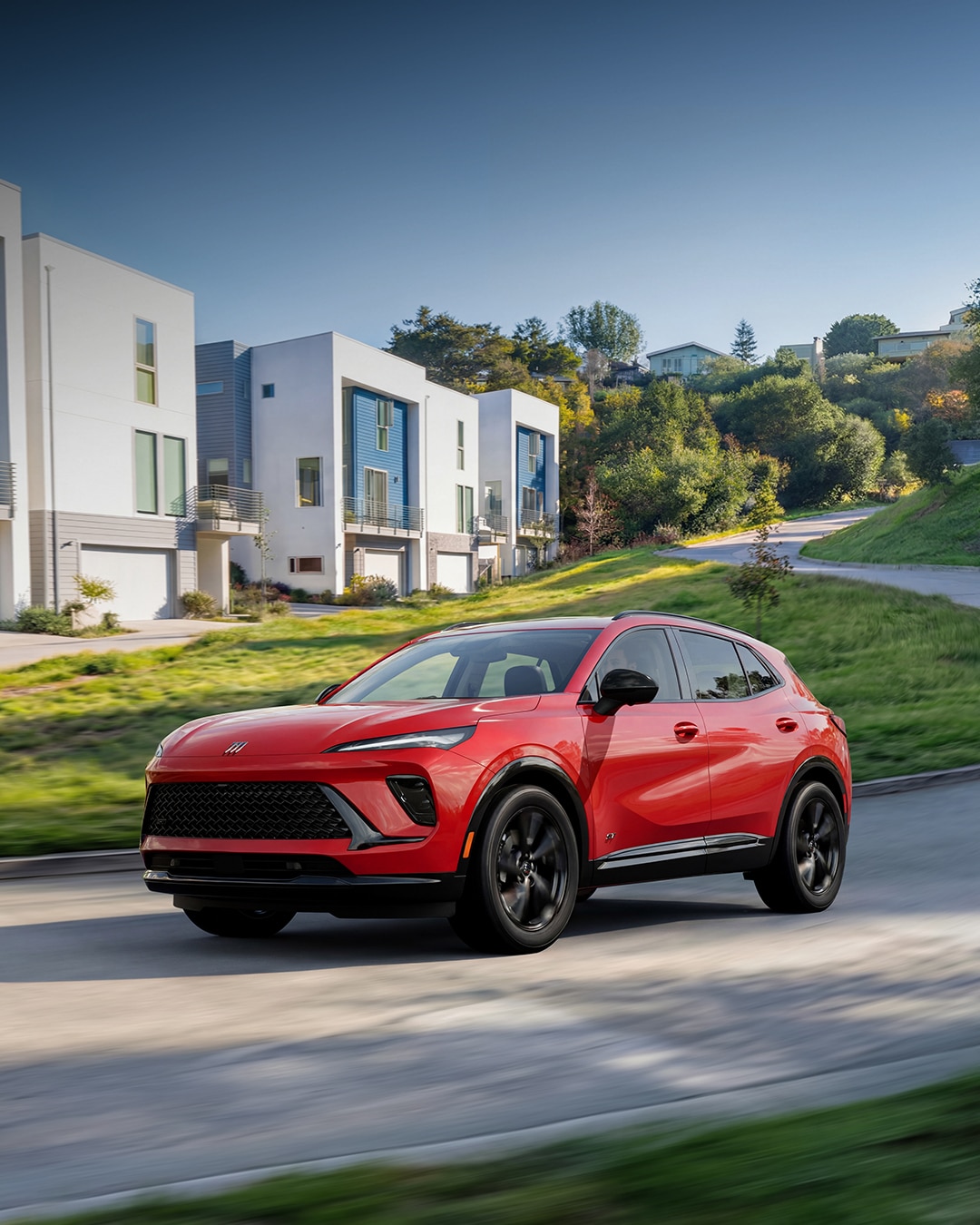 A Red Buick Envision SUV Parked in Front of a Modern House