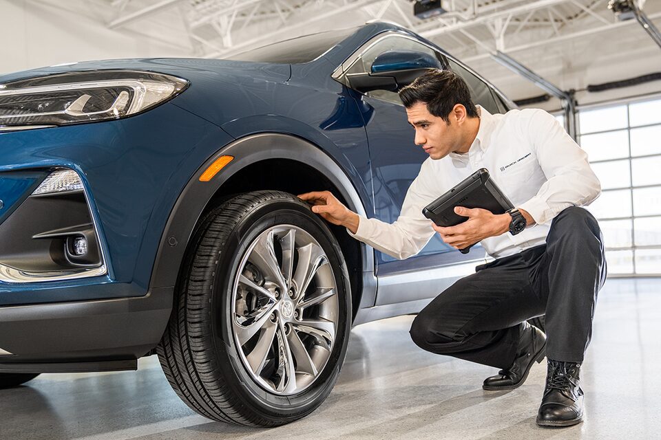 Buick Certified Service Representative Inspecting a Vehicle's Tire
