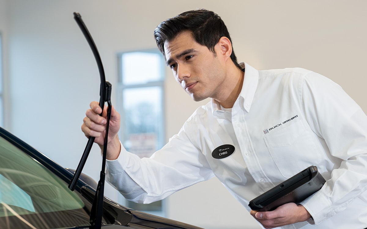 A Dealership Employee Is Inspecting a Wind Shield Wiper on a Vehicle