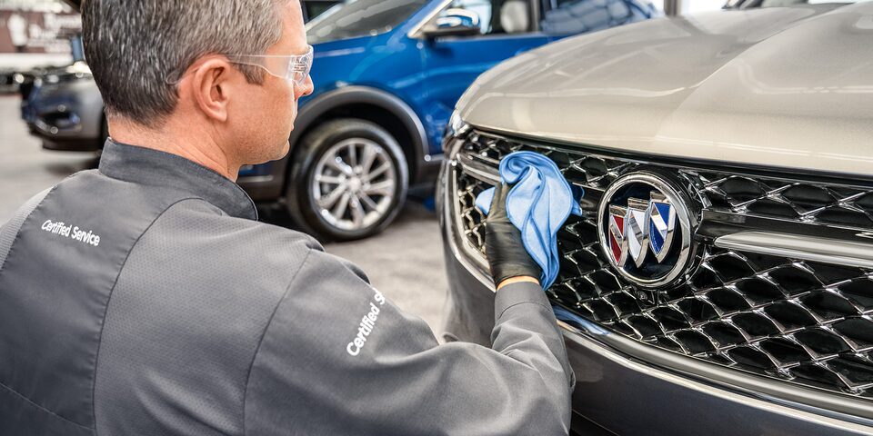 Buick Certified Service Technician Cleaning the Grille on a Buick Vehicle