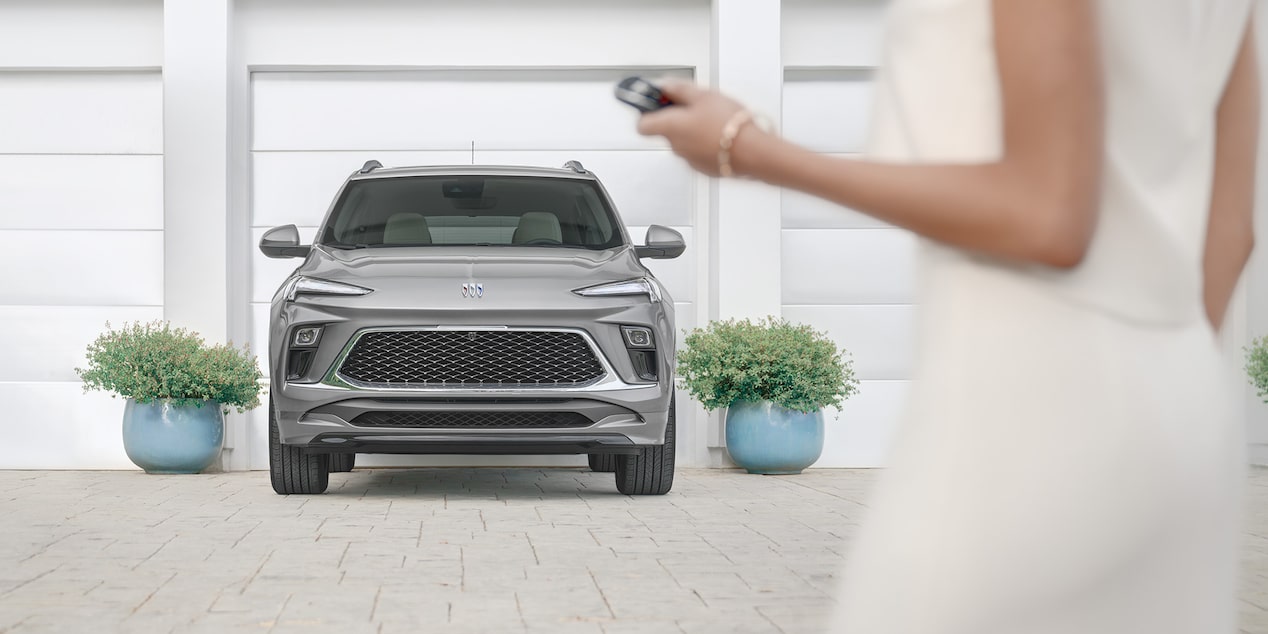 A Woman Unlocking a Grey Buick Encore GX