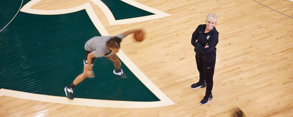 MSU Basketball Coach Suzy Merchant Stands on Court Wide View