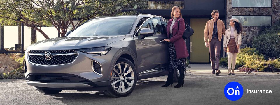 Buick Avenir parked in the driveway of a modern home. Woman is at the driver’s side door while a man and a young woman walk out of the home. OnStar Insurance logo is in the bottom right corner.