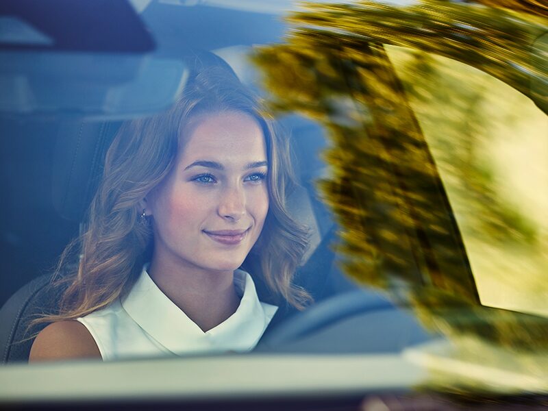 A Woman Smiles as She Enjoys a Ride in Her Buick Encore GX