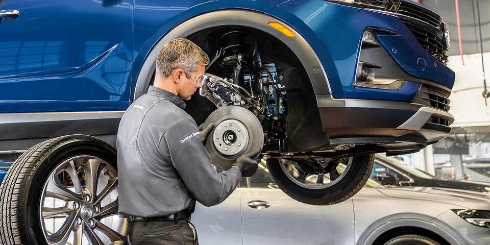 Certified Service Technician installing a brake rotor